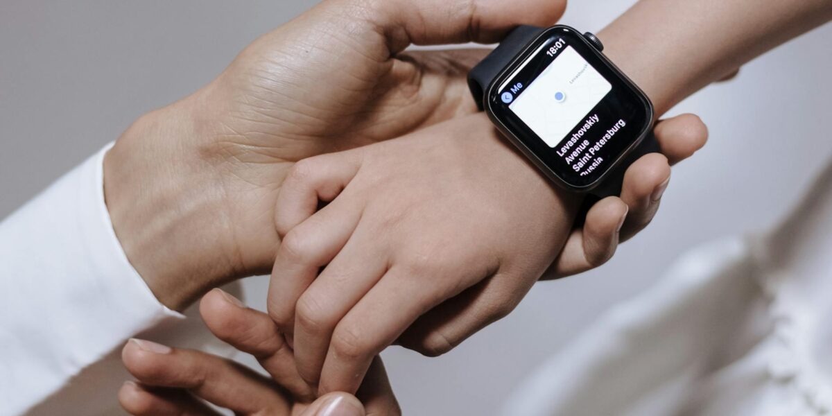 Close-up of a mother assisting her daughter with a smartwatch, emphasizing family care and technology.