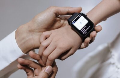 Close-up of a mother assisting her daughter with a smartwatch, emphasizing family care and technology.