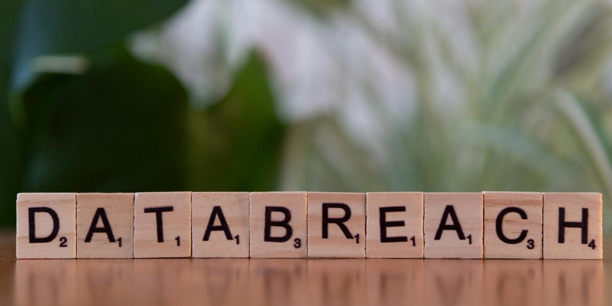 Close-up of Scrabble tiles spelling 'data breach' on a blurred background