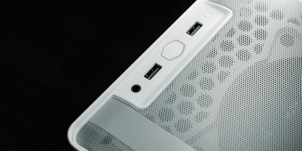 Detailed view of USB and audio ports on a white computer case, showcasing modern technology design.