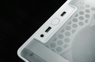 Detailed view of USB and audio ports on a white computer case, showcasing modern technology design.