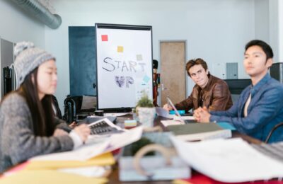 A group of young professionals brainstorming ideas in a startup office setting.