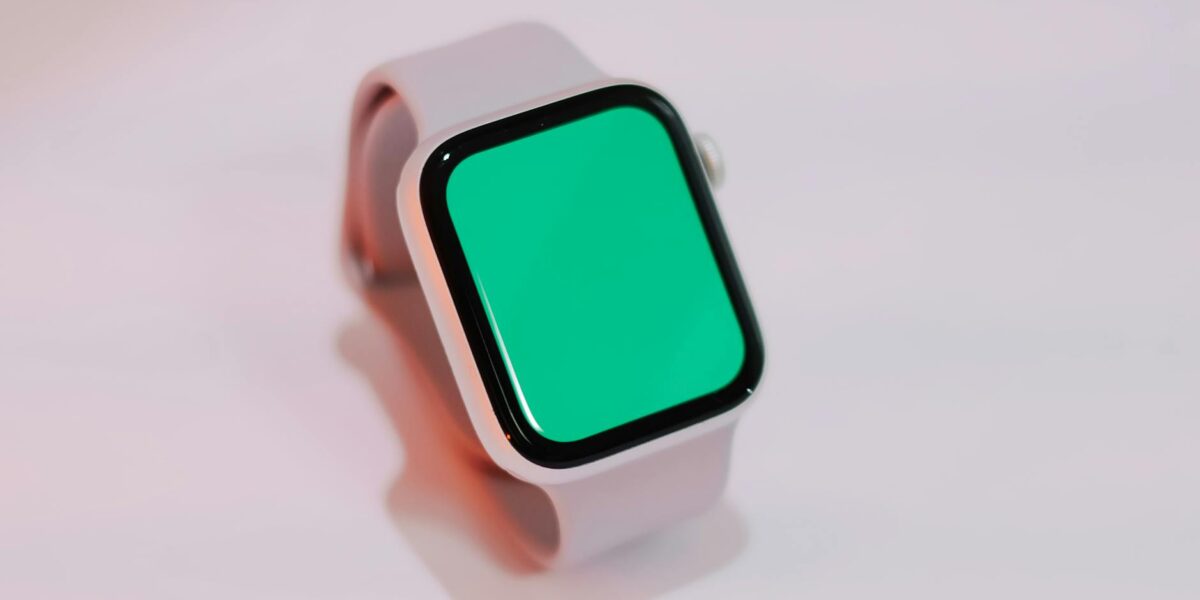 Smartwatch with a blank green screen displayed on a light background, suitable for mockups.