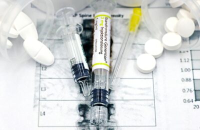 Close-up of syringes and pills on a bone density exam sheet, depicting osteoporosis treatment.