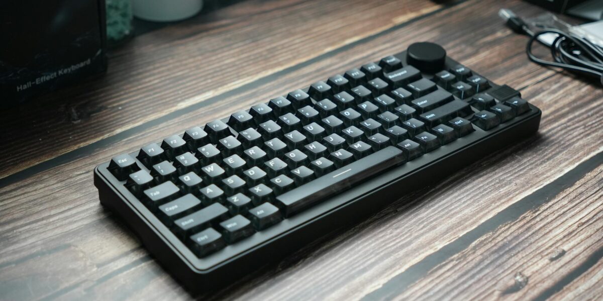 A sleek black mechanical keyboard placed on a wooden desk, ideal for gaming or office use.
