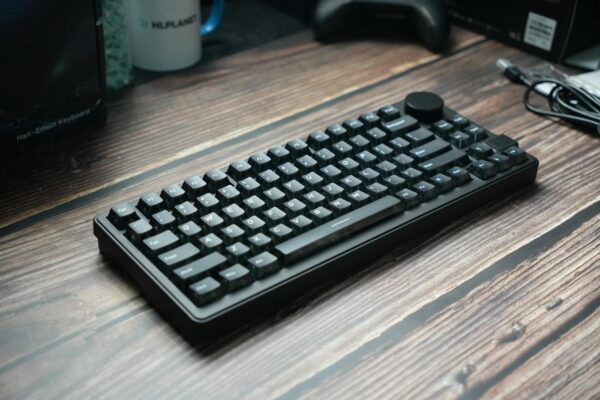 A sleek black mechanical keyboard placed on a wooden desk, ideal for gaming or office use.