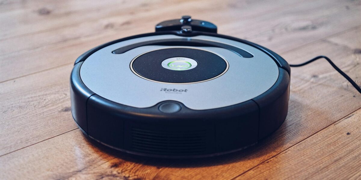 Close-up of a robotic vacuum cleaner operating on a hardwood floor, showcasing modern cleaning technology.