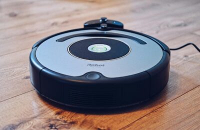 Close-up of a robotic vacuum cleaner operating on a hardwood floor, showcasing modern cleaning technology.