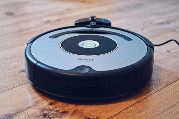 Close-up of a robotic vacuum cleaner operating on a hardwood floor, showcasing modern cleaning technology.
