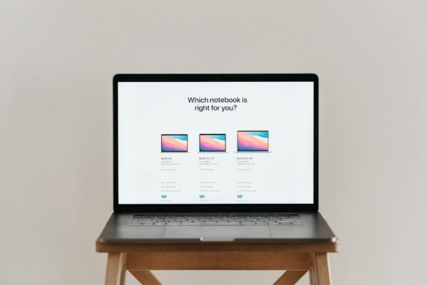 An open laptop on a wooden stool showing a notebook comparison chart, ideal for tech-focused imagery.
