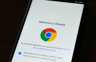 Close-up of smartphone displaying Google Chrome's welcome page and logo.