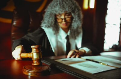 Female judge in a courtroom setting, focusing on legal documents with a gavel.