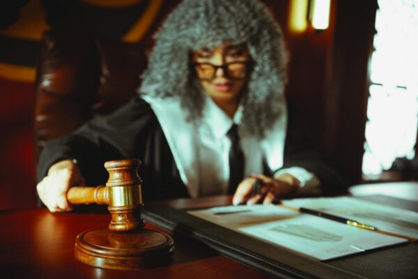 Female judge in a courtroom setting, focusing on legal documents with a gavel.