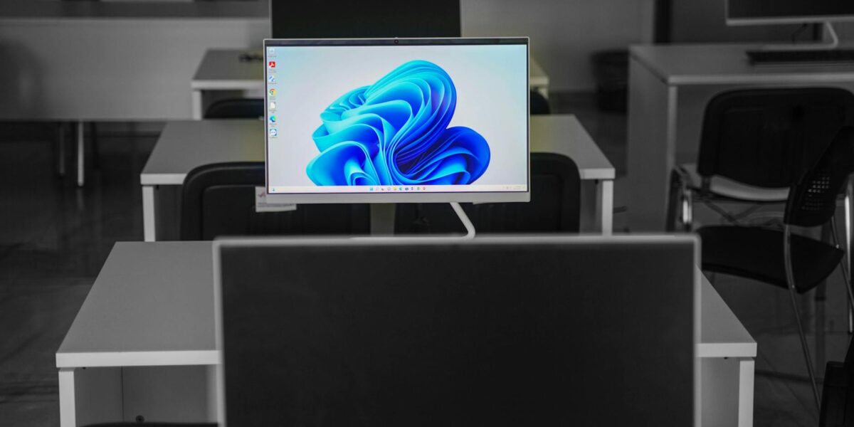 A contemporary office setup featuring computers on desks with modern flat screens.