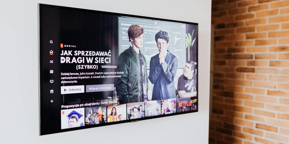 Smart TV displaying streaming content in modern living room setting with exposed brick wall.
