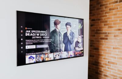 Smart TV displaying streaming content in modern living room setting with exposed brick wall.