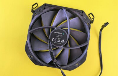 Black computer cooling fan with wire on vibrant yellow background. Ideal for technology content.