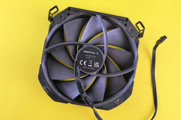Black computer cooling fan with wire on vibrant yellow background. Ideal for technology content.