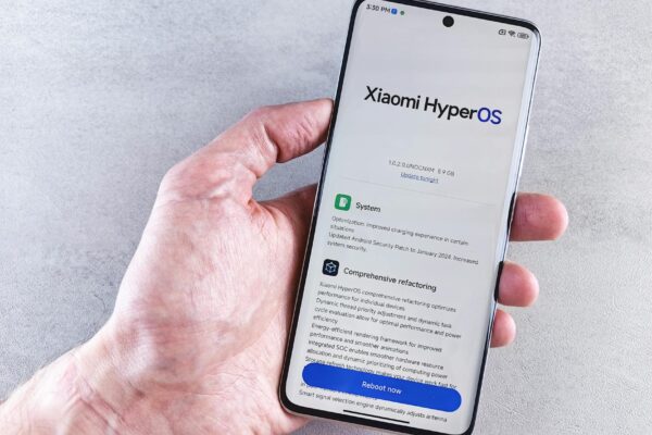 Close-up of a hand holding a Xiaomi smartphone with HyperOS interface, showcasing comprehensive refactoring and system update details.