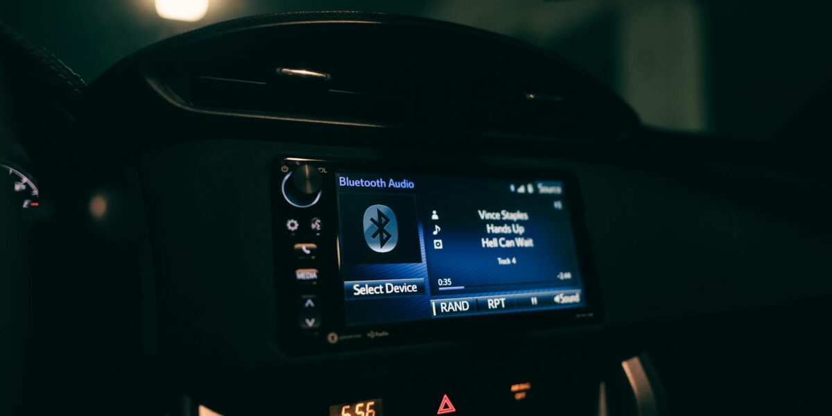 Close-up view of a car's dashboard at night displaying Bluetooth audio system.