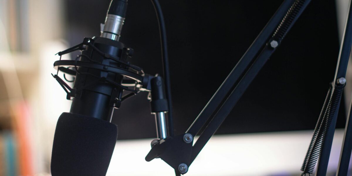 Close-up of a condenser microphone in a studio setting, ideal for podcasts and audio recording.