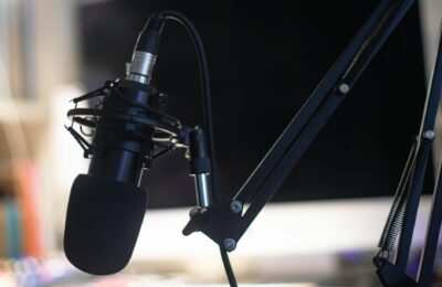 Close-up of a condenser microphone in a studio setting, ideal for podcasts and audio recording.