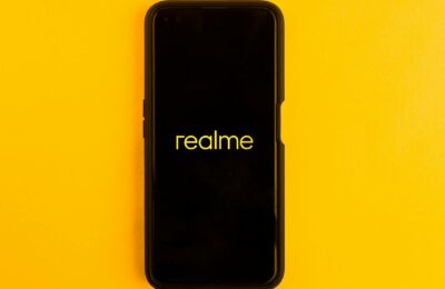 Realme smartphone displayed against a bright yellow backdrop, emphasizing modern technology.