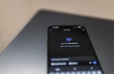 Close-up of a smartphone with AI assistant interface on screen over a laptop.