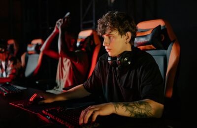 Competitive gamers in an esports tournament concentrating deeply in dimly lit setting.