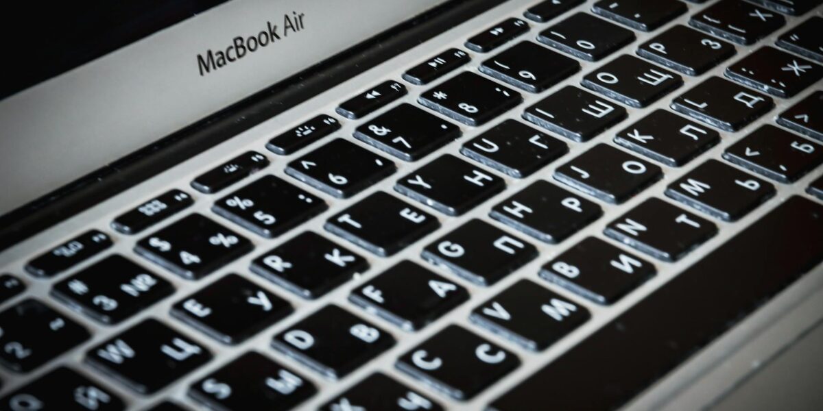Detailed close-up of a MacBook Air keyboard featuring Cyrillic characters, capturing sleek technology.