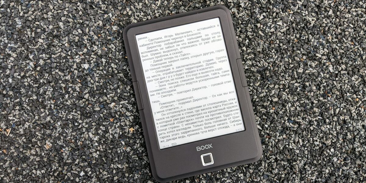 Digital BOOX e-book reader placed on a textured gravel surface, offering a tech contrast.
