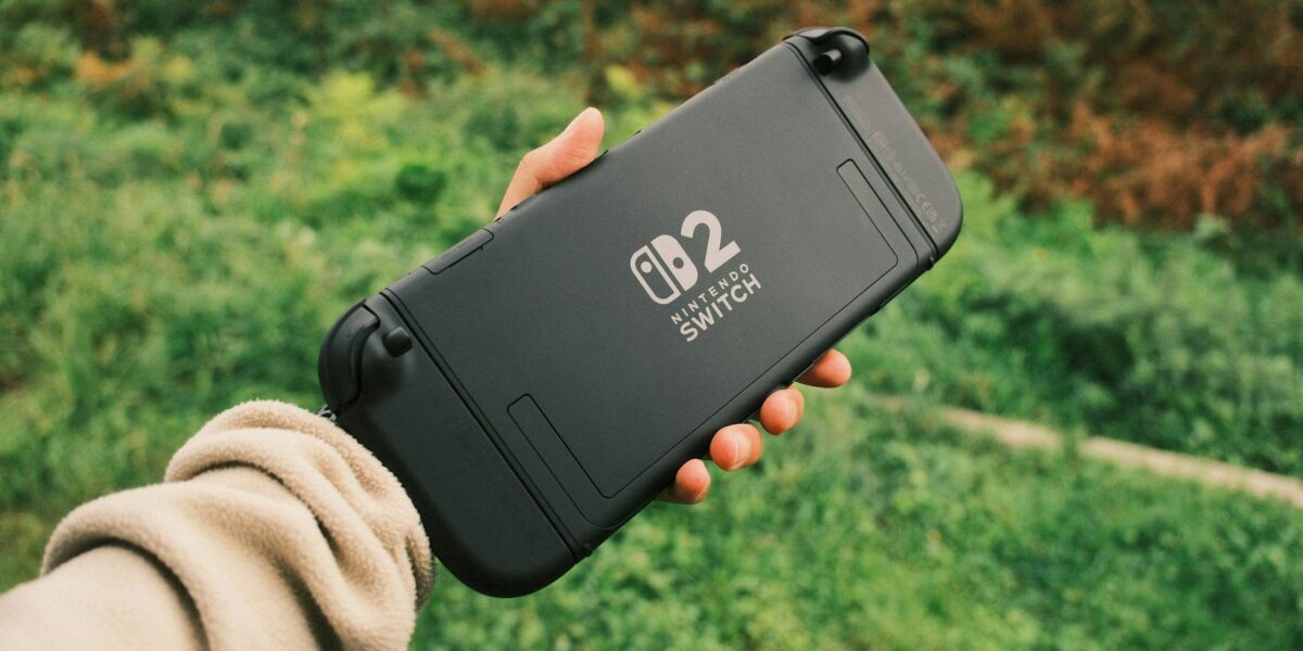 Person holding a Nintendo Switch in a natural outdoor setting, perfect for on-the-go gaming.