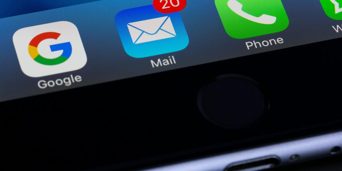 A close-up photo of a smartphone displaying popular apps like Google and Mail.