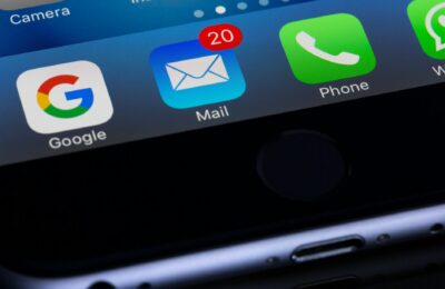 A close-up photo of a smartphone displaying popular apps like Google and Mail.