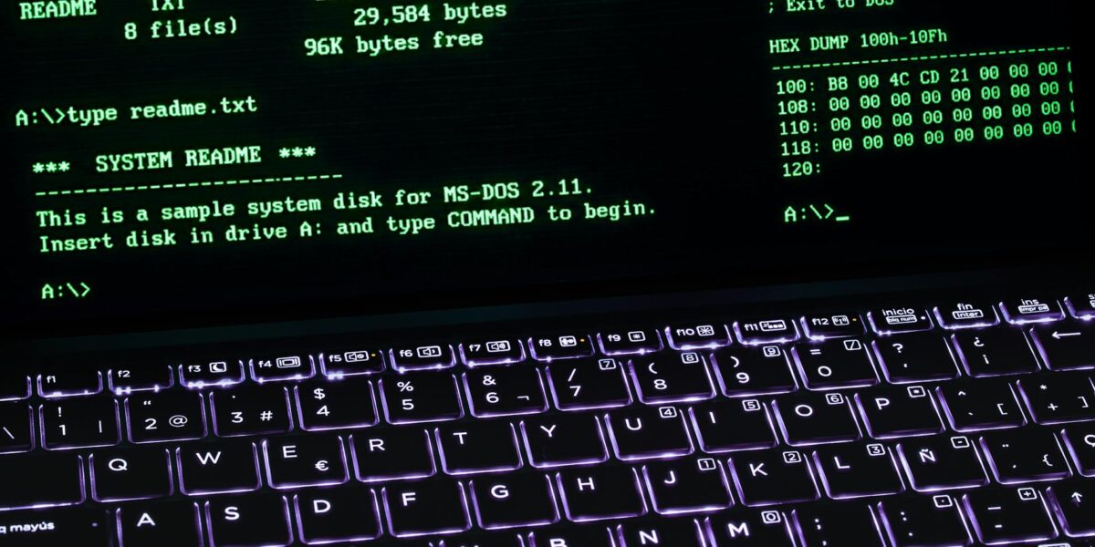 A classic MS-DOS terminal screen displayed on a laptop keyboard with vivid illumination.