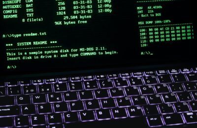 A classic MS-DOS terminal screen displayed on a laptop keyboard with vivid illumination.
