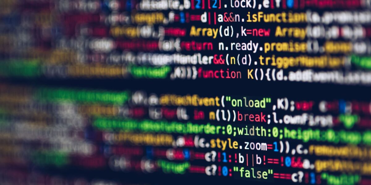 Vivid, blurred close-up of colorful code on a screen, representing web development and programming.