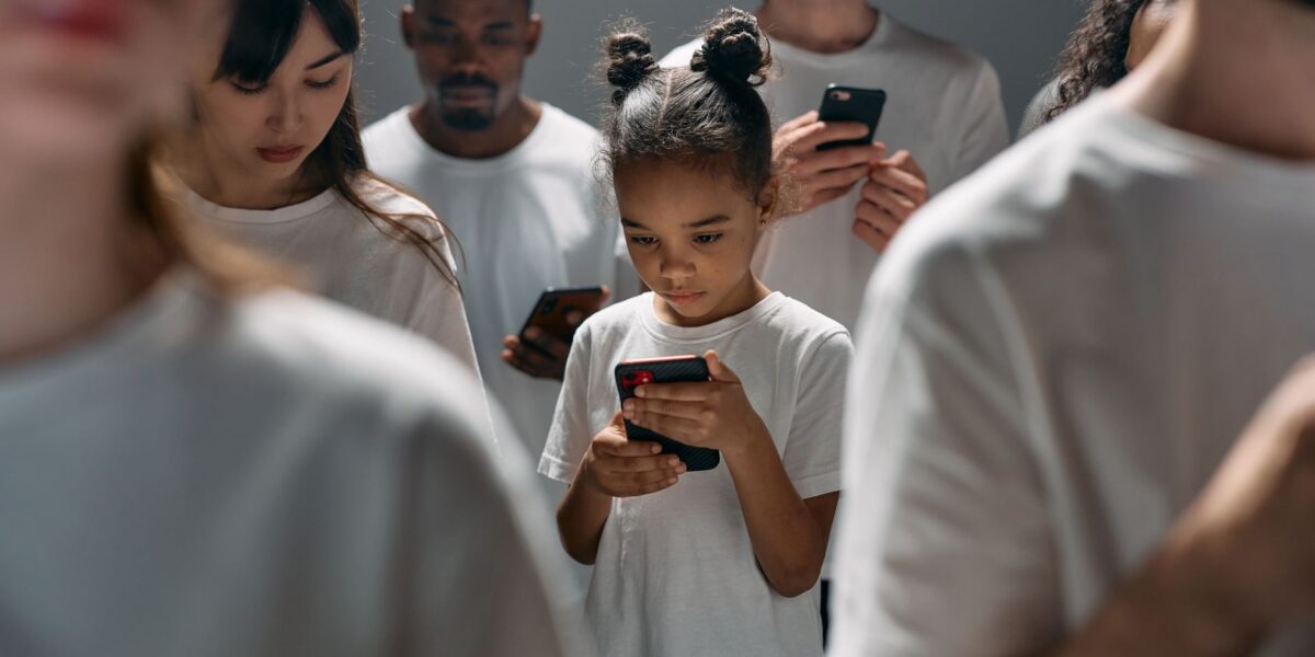 A diverse group of people focused on their smartphones, illustrating social connection and technology indoors.