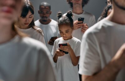 A diverse group of people focused on their smartphones, illustrating social connection and technology indoors.