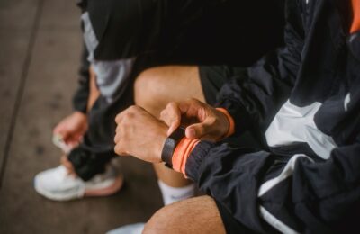Close-up of a man in athletic wear adjusting a smartwatch, showcasing fitness and technology integration.