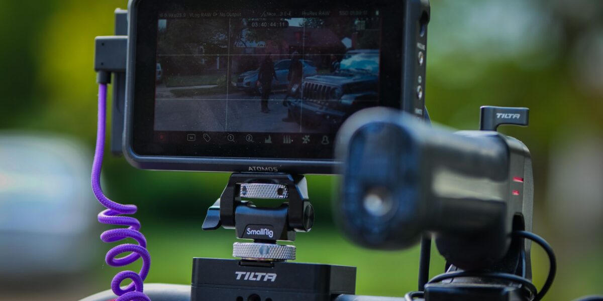 Close-up of a camera rig with monitor in a sunny outdoor setting.