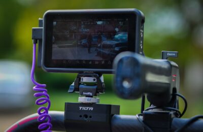 Close-up of a camera rig with monitor in a sunny outdoor setting.