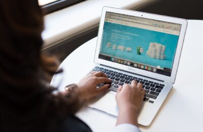 Businesswoman working on laptop with Android 6.0 Marshmallow webpage open.