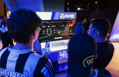 Group of gamers engaged in a PS5 event, choosing teams on a football game selection screen.