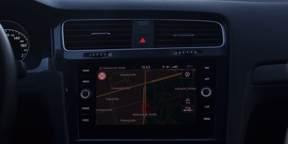 Interior of modern car with steering wheel and navigation system showing route through city streets