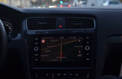 Interior of modern car with steering wheel and navigation system showing route through city streets