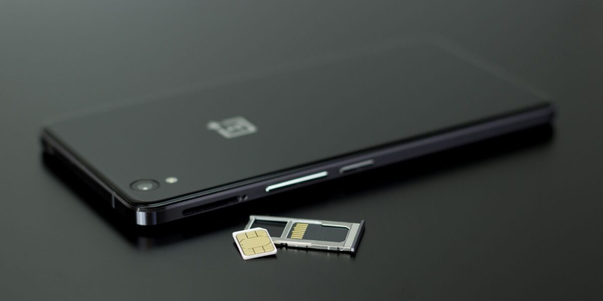 Close-up of a smartphone with a SIM card and memory card, showcasing modern technology.