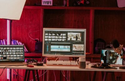 A professional video editing workspace featuring monitors, keyboard, and microphones in a studio setting.