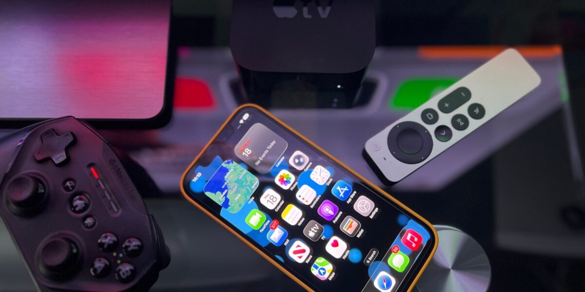 Stylish home entertainment setup featuring an iPhone, Apple TV, and gaming controller on a dark surface.