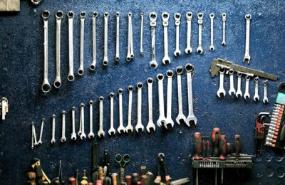 Neatly arranged wrenches and tools on a workshop wall, ideal for mechanics.